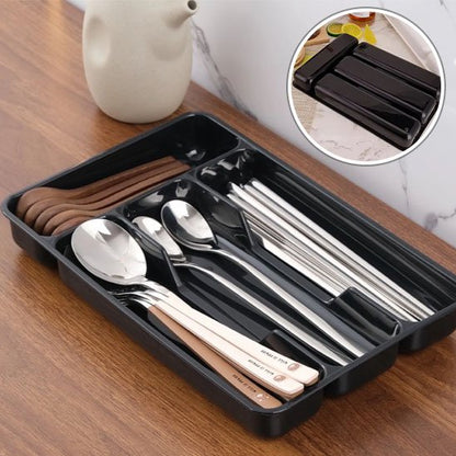 range couvert noir sur table vase a cote